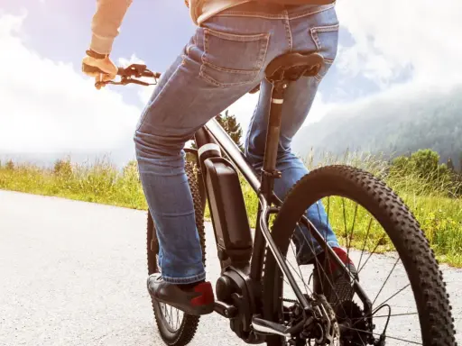 Osoba na rowerze elektrycznym cieszy się jazdą po malowniczej trasie. Dofinansowanie do roweru sprawia, że takie wycieczki są dostępne dla każdego.