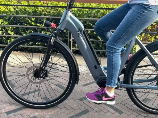 Osoba na rowerze elektrycznym Grundig, ucząc się jak jeździć rowerem elektrycznym, rusza przed siebie.