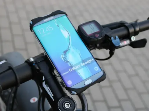 Jaki uchwyt na telefon do roweru? Samsung Galaxy S6 edge+ zamontowany na kierownicy roweru, obok licznika.
