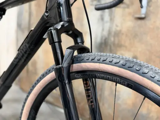 Czarny rower gravelowy marki Trek, z widocznym amortyzatorem i oponą Bontrager. To świetny wybór dla miłośników przygód.