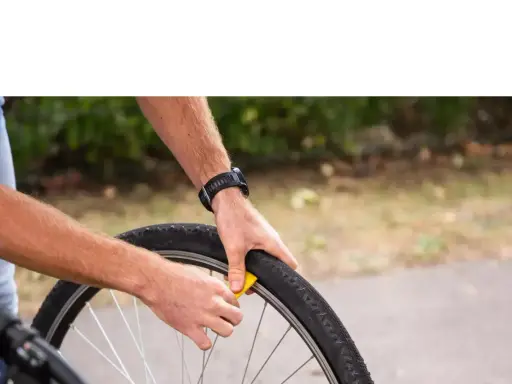 Rowerzysta wymienia oponę. Zastanawiasz się, gdzie wyrzucić opony rowerowe? Sprawdź lokalne punkty zbiórki odpadów.