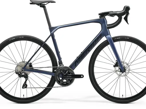 Granatowy rower szosowy endurance z hamulcami tarczowymi i napędem Shimano 105. Idealny na długie trasy.