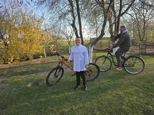 Chłopiec w albie i mężczyzna na rowerach. Pomarańczowy rower 29 cali na jaki wzrost?