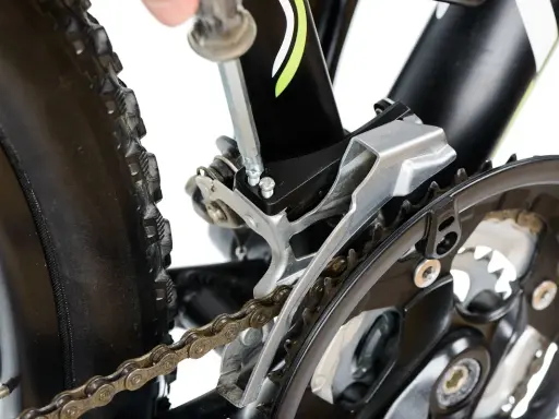 Naprawa roweru: wymiana linki przerzutki przedniej Shimano. Klucz imbusowy dokręca śruby mocujące przerzutkę.