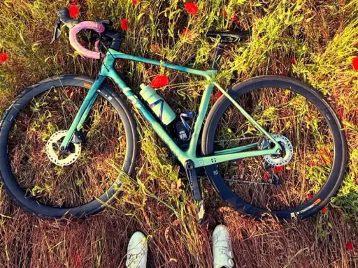 Zielony rower leży wśród maków. Idealna wysokość siodełka wzór do podziwiania natury.