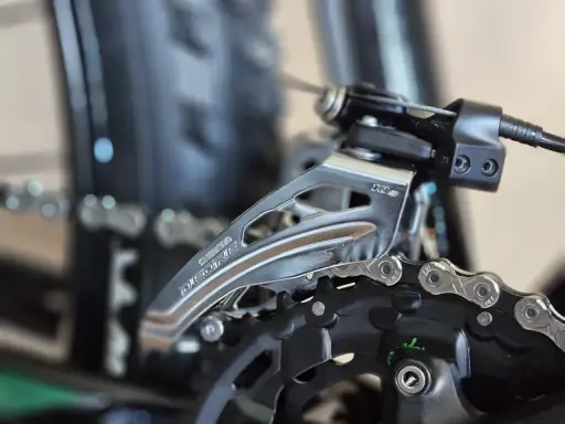 Zbliżenie na przednią przerzutkę rowerową Shimano Deore. Dowiedz się, jak zmieniać przerzutki w rowerze, by jazda była płynniejsza.