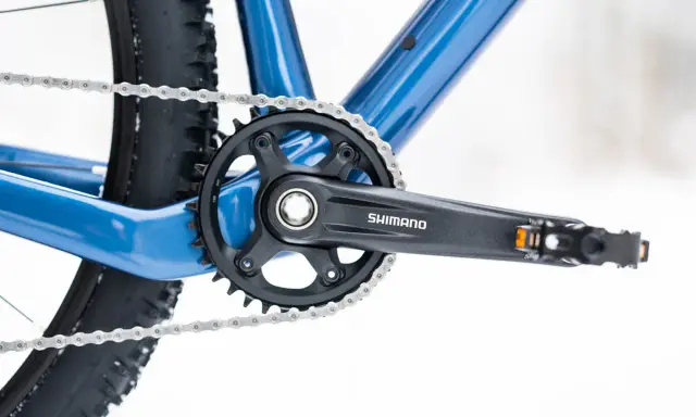 Widok na korbę rowerową Shimano i łańcuch. Dowiedz się, jak odkręcić zapieczone pedały w rowerze, gdy napotkasz takie problemy.
