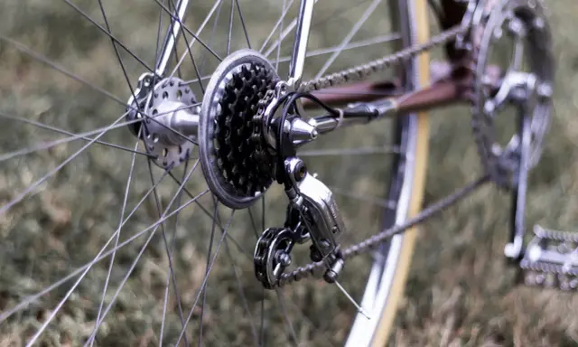 Błyszczący mechanizm przerzutek rowerowych, gotowy do precyzyjnej regulacji.