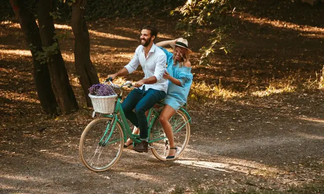 Para wzrostu 160-170 cm, rama 15 cali na rowerze z koszykiem kwiatów, na którym jedzie uśmiechnięta para.