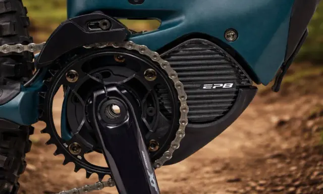Zbliżenie na napęd roweru elektrycznego z systemem **Shimano STEPS**. Widoczna korba, zębatka, łańcuch i obudowa silnika z napisem EP8.