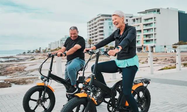 Uśmiechnięci seniorzy na rowerach hybrydowych. Jak działa taki rower? Pomaga w jeździe, dodając mocy!