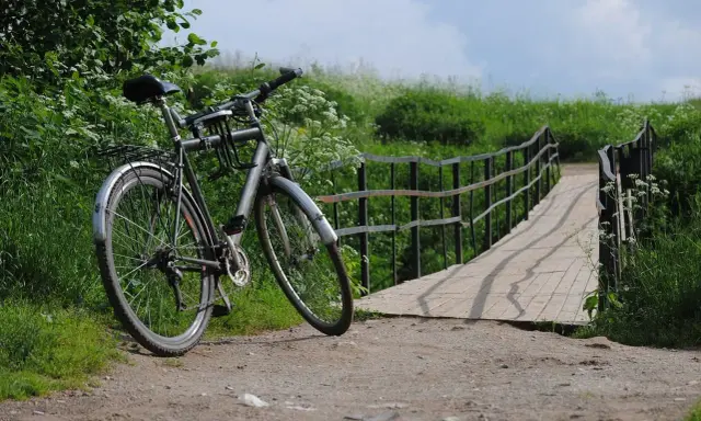 Rower czeka przy moście, gotowy na dalszą podróż. Idealne miejsce na noclegi dla rowerzystów, gdzie można odpocząć po dniu pełnym wrażeń.