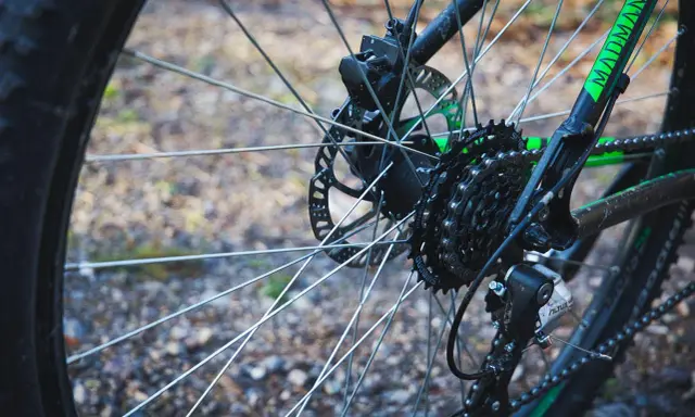 Tylne koło roweru z widocznym elementem przekładni rowerowej: kasetą z zębatkami Shimano i przerzutką Altus.