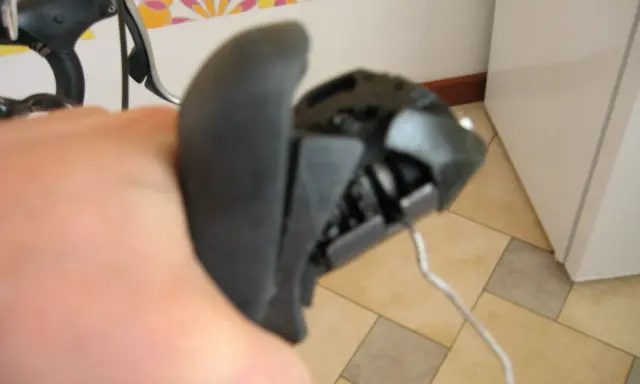 Wymiana linki przerzutki w manetce obrotowej. Widoczna ręka trzymająca manetkę, z której wystaje linka.