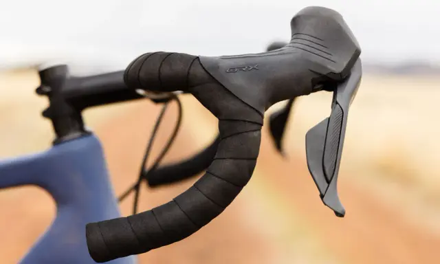 Kierownica gravelowa z owijką i manetkami Shimano GRX, gotowa na przygodę.