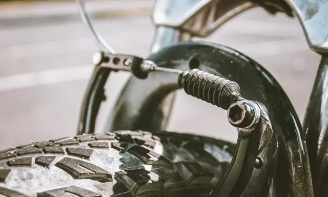 Zbliżenie na mechanizm hamulca rowerowego z widoczną sprężyną i linką. Dowiedz się, jak poluzować hamulce w rowerze.