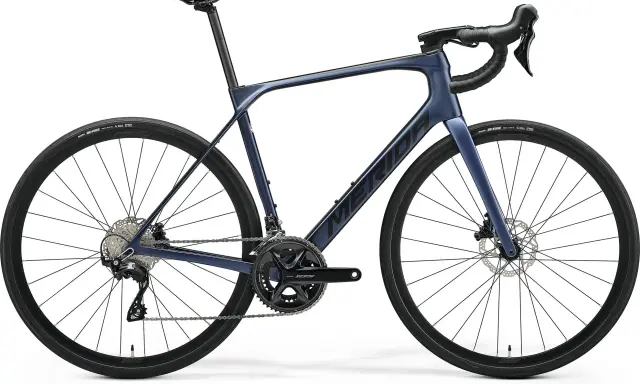 Granatowy rower szosowy endurance z hamulcami tarczowymi i napędem Shimano 105. Idealny na długie trasy.