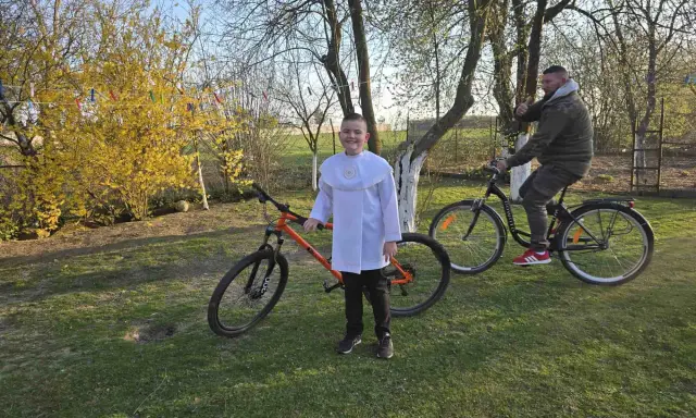 Chłopiec w albie i mężczyzna na rowerach. Pomarańczowy rower 29 cali na jaki wzrost?