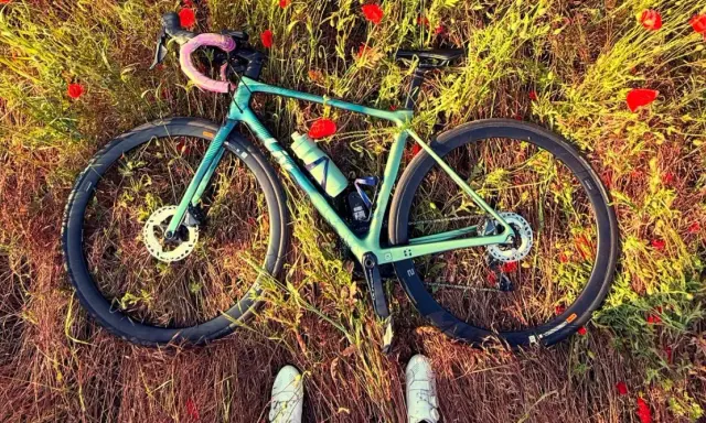 Zielony rower leży wśród maków. Idealna wysokość siodełka wzór do podziwiania natury.