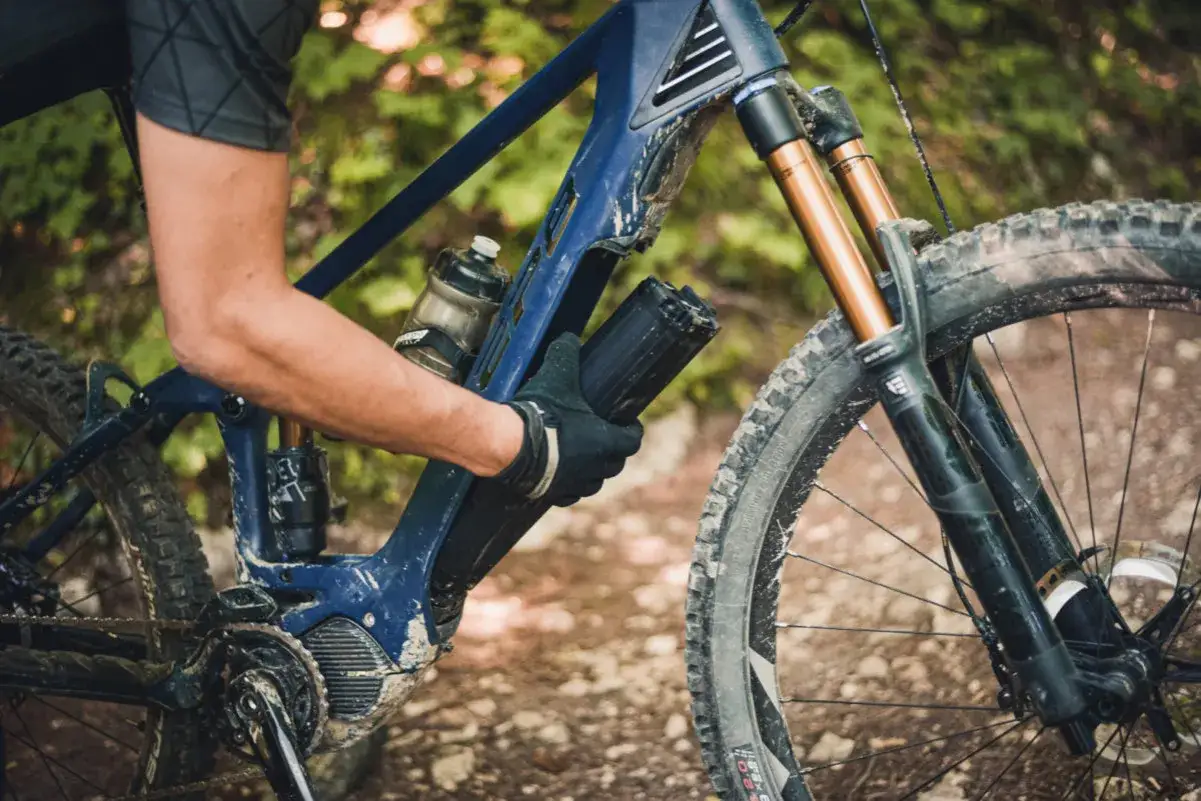 Rowerzysta wyjmuje baterię z napędu Shimano EP8 w rowerze g&oacute;rskim.