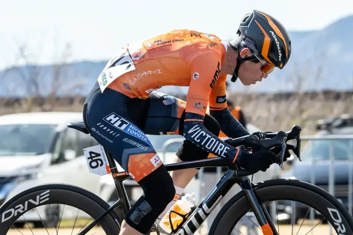Kolarz w pomarańczowym stroju z numerem 46 na rowerze, intensywny cardio na rowerze.