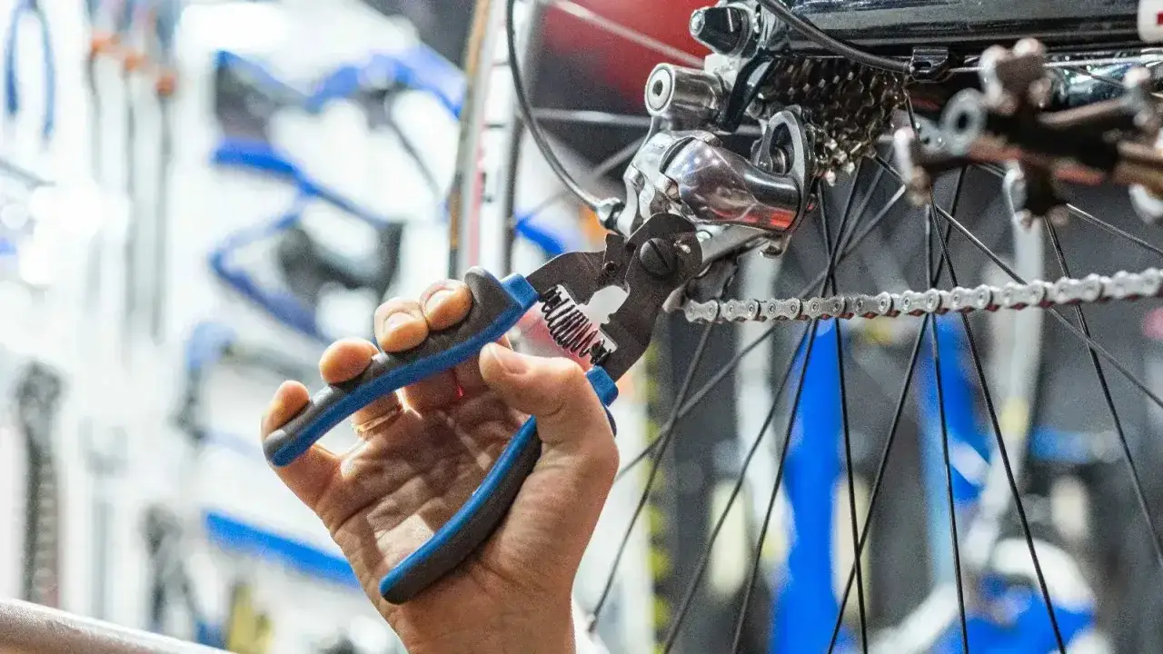 Ręka z narzędziem przy przerzutce i łańcuchu roweru elektrycznego. Jaki łańcuch do roweru elektrycznego?