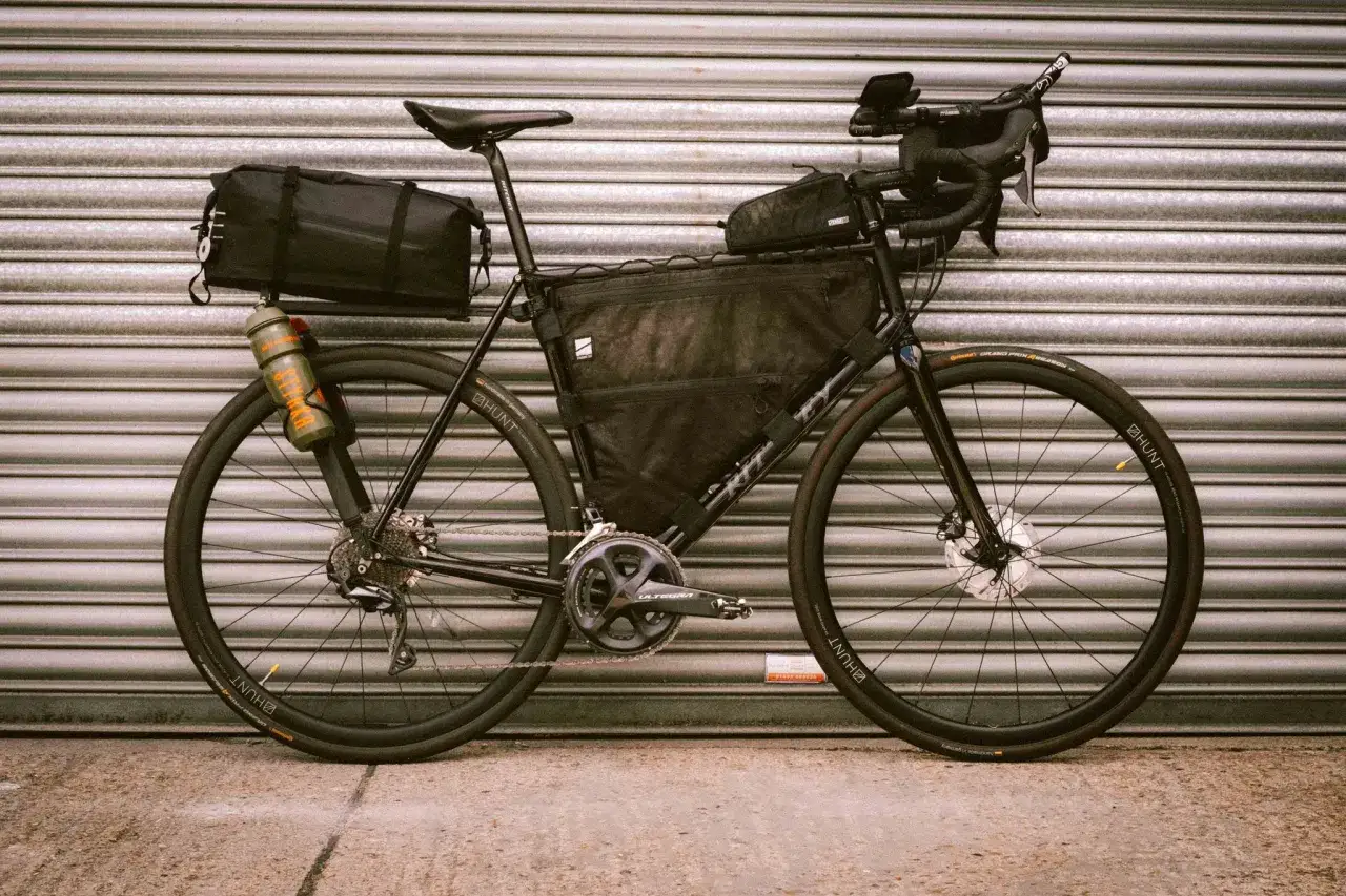 Czarny rower szosowy z sakwami, gotowy na długą podróż. Idealny do bikepackingu i odkrywania nowych tras.