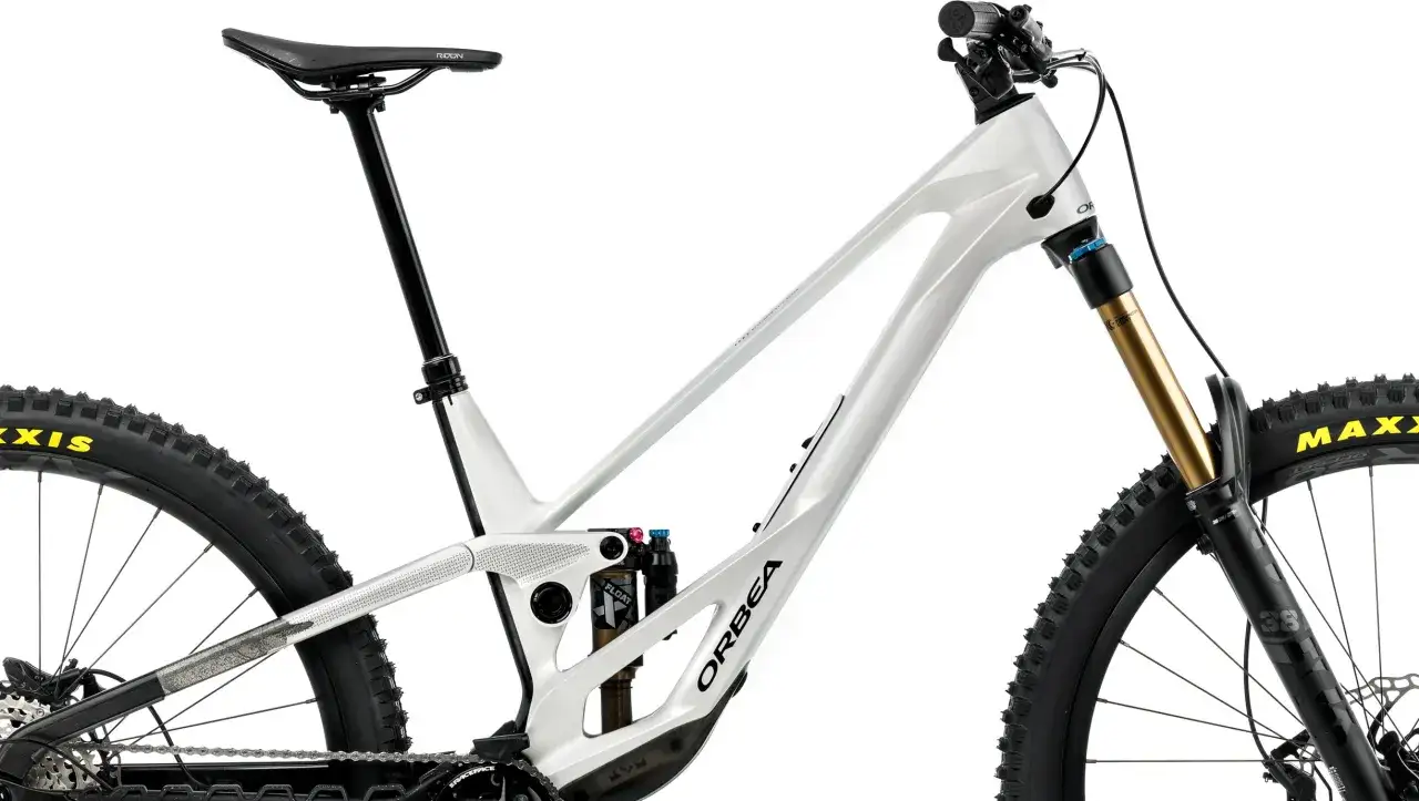 Biały rower enduro Orbea z pełnym zawieszeniem, amortyzatorem Fox i oponami Maxxis. Idealny do pokonywania trudnych tras.
