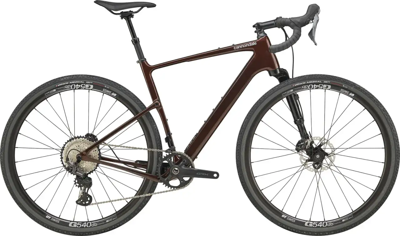 Brązowy rower gravelowy Cannondale Topstone Carbon 3 z napędem Shimano GRX i oponami Vittoria Mezcal. Gotowy na każdą trasę.