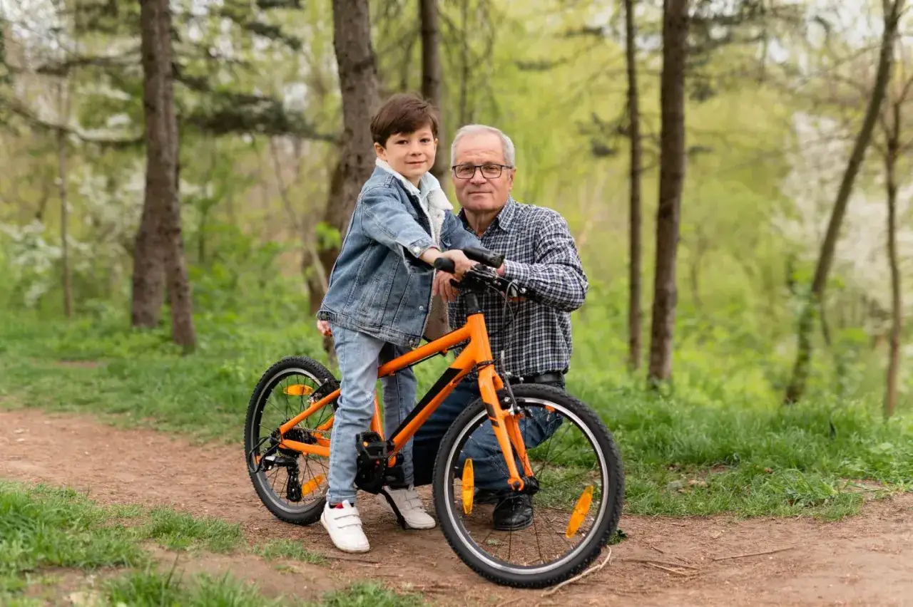 Chłopiec na rowerze z dziadkiem. Koła 20 cali na jaki wzrost? Idealne na pierwsze rowerowe przygody w lesie.