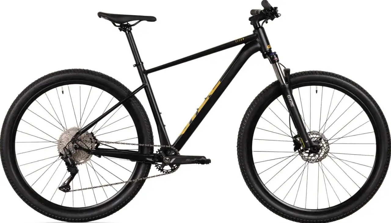 Czarny rower xc z żółtymi akcentami, amortyzatorem z przodu i przerzutkami Shimano. Gotowy na każdą trasę!