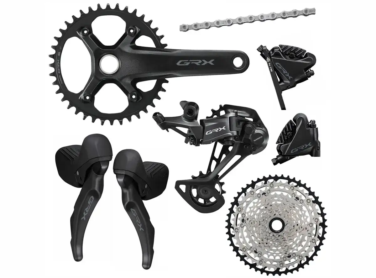 Zestaw komponentów rowerowych Shimano GRX: korba, przerzutka, manetki, hamulce i kaseta.