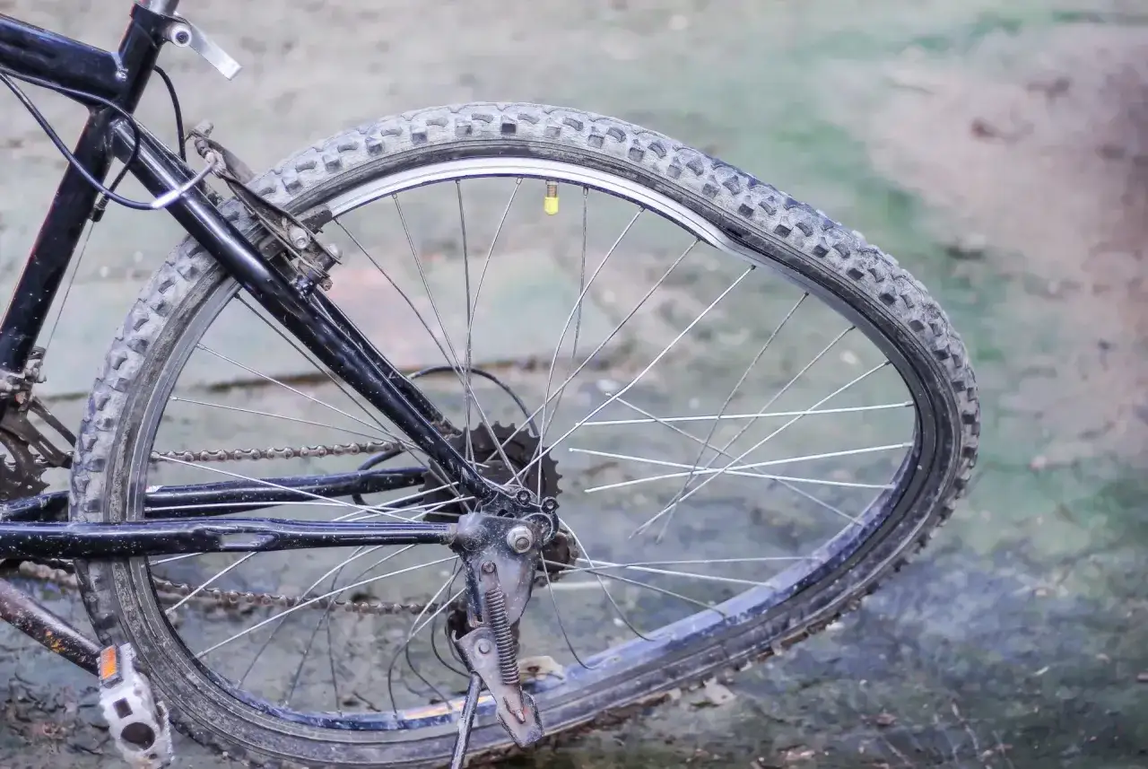 Zniszczona opona rowerowa leży na ziemi. Zastanawiasz się, gdzie wyrzucić opony rowerowe?