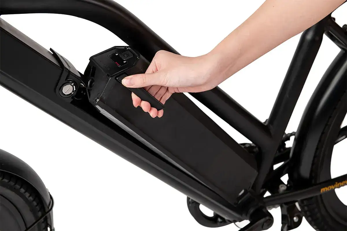 Dłoń wyjmuje baterię z ramy roweru elektrycznego, pokazując, czy można doładowywać baterię w rowerze.